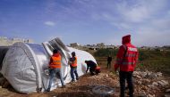 QRCS representatives setting up a tent for internally displaced people in Syria. 
