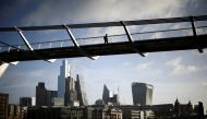 FILE PHOTO: The City of London financial district is seen as people walk over Millennium Bridge in London, Britain, February 16, 2022. REUTERS/Henry Nicholls/File Photo
