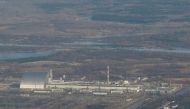 FILE PHOTO: An aerial view from a plane shows a New Safe Confinement (NSC) structure over the old sarcophagus covering the damaged fourth reactor at the Chernobyl Nuclear Power Plant during a tour to the Chernobyl exclusion zone, Ukraine April 3, 2021. REUTERS/Gleb Garanich/File Photo
