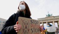 People hold signs as they demonstrate at Brandenburg Gate, after Russian President Vladimir Putin authorized a military operation in eastern Ukraine, in Berlin, Germany February 24, 2022. REUTERS/Michele Tantussi