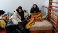 Women look on at a refugee shelter after fleeing Russia's invasion of Ukraine, in Beregsurany, Hungary, February 28, 2022. REUTERS/Bernadett Szabo