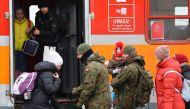 Polish army soldiers assist people to board a train to Krakow after crossing the border from Ukraine to Poland, after fleeing the Russian invasion of Ukraine, at the border checkpoint in Medyka, Poland, March 9, 2022. REUTERS/Fabrizio Bensch