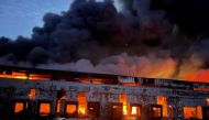 A warehouse storing frozen products is seen on fire after shelling, as Russia's attack on Ukraine continues, in the village of Kvitneve in Kyiv region, Ukraine, in this handout picture released March 12, 2022. Press service of the State Emergency Service of Ukraine/Handout via Reuters 