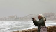 Tourists take pictures during storm Celia on La Mata beach, in Torrevieja, Spain March 15, 2022. REUTERS.