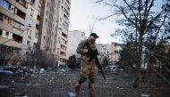 A member of the Ukrainian military surveys an area next to a residential building that was hit by an intercepted missile, as Russia's invasion of Ukraine continues, in Kyiv, Ukraine March 17, 2022. REUTERS/Thomas Peter