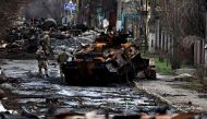 A soldier takes a photograph of his comrade as he poses beside a destroyed Russian tank and armoured vehicles, amid Russia's invasion on Ukraine in Bucha, in Kyiv region, Ukraine April 2, 2022. REUTERS/Zohra Bensemra/File Photo