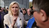 Marine Le Pen, French far-right National Rally (Rassemblement National) party candidate for the 2022 French presidential election, talks with a supporter, in Soucy, France, April 11, 2022. Reuters/Sarah Meyssonnier