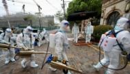 Volunteers in protective suits prepare to disinfect a residential compound in Huangpu district, to curb the spread of the coronavirus disease (COVID-19), in Shanghai, China. China Daily via REUTERS 