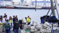 Police officers discharge drugs from the fishing boat 