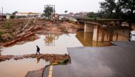 A man walks around a damaged bridge caused by flooding in Umlazi near Durban, South Africa, April 16, 2022. REUTERS/Rogan Ward/File Photo