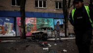 People walk past a destroyed car, following Russian shelling, as Russia's attack on Ukraine continues, in Kharkiv, Ukraine, April 18, 2022. REUTERS/Alkis Konstantinidis
