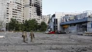 Ukrainian servicemen walk at a damaged area, as Russia's attack on Ukraine continues, in Kharkiv, Ukraine, May 14, 2022. REUTERS/Ricardo Moraes