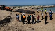 A 30-tonne, 14-metre-long whale that washed up dead on the beach is tied to an excavator, in the Valencian town of Tavernes de la Valldigna, Spain, May 27, 2022. REUTERS/Eva Manez
