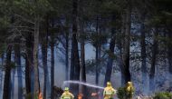 Firefighters work to extinguish a wildfire at the Sierra de la Culebra near Ferreras de Arriba, Zamora, Spain, June 19, 2022. REUTERS/Isabel Infantes