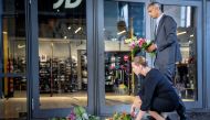 Danish Prime Minister Mette Frederiksen and Justice Minister Mattias Tesfaye lay flowers outside Field's shopping centre before their news conference, a day after a shooting occurred at the mall, in Copenhagen, Denmark, July 4, 2022. (Reuters)