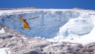 A helicopter participates in a search and rescue operation over the site of a deadly collapse of parts of a mountain glacier in the Italian Alps amid record temperatures, at Marmolada ridge, Italy July 6, 2022. REUTERS/Guglielmo Mangiapane