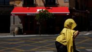A tourist shelters from the sun underneath a jacket during the second heatwave of the year in Madrid, Spain, July 10, 2022. (REUTERS/Susana Vera)