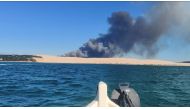 A general view shows smoke rising from the Gironde forest fires as seen from Dune de Pilat, Arcachon Bay, France July 12, 2022 in this still image obtained from a social media video. Quentin/via REUTERS
