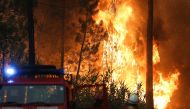 Firefighters watch a wildfire in Ourem, Santarem district, Portugal, July 12, 2022. (REUTERS/Rodrigo Antunes)

