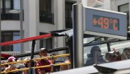 A tourist bus rides past a thermometer displaying 49 Celsius degrees (120.2 Fahrenheit degrees) at Gran Via during the second heatwave of the year in Madrid, Spain, July 15, 2022. (REUTERS/Isabel Infantes)