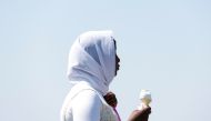 A woman stands with ice cream, during a heatwave in Brighton, Britain, July 19, 2022. (REUTERS/Peter Cziborra)
