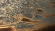 People walk on the beach during a heatwave in Blackpool, Britain, July 19, 2022. REUTERS/Molly Darlington
