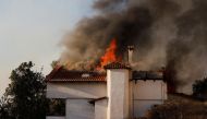 A house is engulfed by flames during a wildfire in Pallini, near Athens, Greece, on July 20, 2022. (REUTERS/Costas Baltas)