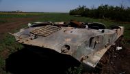 A Ukrainian soldier walks past destroyed Russian tanks in a field, in Mykolaiv region, Ukraine, on June 12, 2022. (REUTERS/Edgar Su)