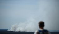 A man watches as smoke rises up above the Grunewald forest due to an explosion in a munitions depot in the Grunewald forest in Berlin, Germany August 4, 2022. REUTERS/Annegret Hilse
