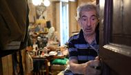 Angelo Casciano, 79, stands at his house as he receives a package of items from volunteers providing food and drink for the elderly, as part of the Heat Plan during a heatwave in Milan, Italy, August 5, 2022. REUTERS/Flavio Lo Scalzo