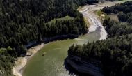 A tourist boat sails back at the end of the Doubs canyon on the drought-affected Doubs River on the border with France in Les Brenets, Switzerland, August 8, 2022. REUTERS/Denis Balibous