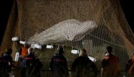 Firefighters and members of a search and rescue team pull up a net as they rescue the Beluga whale, near the Notre-Dame-de-la-Garenne lock in Saint-Pierre-la-Garenne, France, August 10, 2022. Reuters/Benoit Tessier