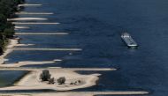 A transport vessel cruises past the partially dried riverbed of the Rhine river in Bingen, Germany, August 9, 2022. REUTERS/Wolfgang Rattay/File Photo