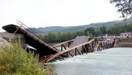 Cars are seen over the collapsed bridge over the River Laagen in Gudbrandsdalen, Norway, August 15, 2022. Geir Olsen/NTB via REUTERS
