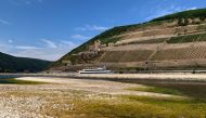 A tourist vessel cruises past the partially dried riverbed of the Rhine river in Bingen, Germany, August 17, 2022. REUTERS/Christian Kraemer/File Photo