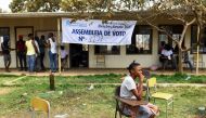 A woman sits outside a voting station after casting her vote during the general election in Cacuaco, Luanda, Angola August 24, 2022. Reuters/Siphiwe Sibeko