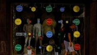 A man walks past mannequins displayed in the window of a store with the lights off to comply with the Spanish government's measures to save energy, in Ronda, Spain, August 25, 2022. (REUTERS/Jon Nazca)