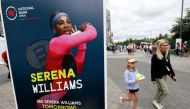 People pass a poster advertising the match of veteran tennis player Serena Williams, who said that she plans to retire after the 2022 US Open, outside a stadium at the National Bank Open in Toronto, Ontario, Canada, August 9, 2022. (REUTERS/Chris Helgren)