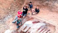 Scientists pose during a phase of the excavation works of a partial skeleton of a sauropod dinosaur at the Monte Agudo fossil site, in Pombal, Portugal in this handout taken August 2022. (Instituto Dom Luiz (Faculty of Sciences of the University of Lisbon via REUTERS) 