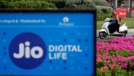 A woman rides her scooter past advertisements of Reliance Industries' Jio telecoms unit, in Ahmedabad, India, on July 5, 2018. REUTERS/Amit Dave