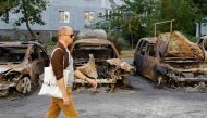A local resident walks past cars destroyed by recent shelling in the course of Ukraine-Russia conflict in the Russian-controlled city of Enerhodar in Zaporizhzhia region, Ukraine, on August 30, 2022.  REUTERS/Alexander Ermochenko