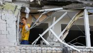 A local resident removes debris inside a multi-storey apartment block damaged by shelling in the course of Ukraine-Russia conflict in the Russian-controlled city of Enerhodar in the Zaporizhzhia region, Ukraine, on September 1, 2022. REUTERS/Alexander Ermochenko