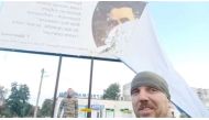 Ukrainian servicemen pull a Russian poster off a billboard, revealing a poem by Taras Shevchenko, following Russia's invasion, in Balakliia, Kharkiv Region, Ukraine, in this screen grab taken from a video obtained by REUTERS released on September 10, 2022. Video obtained by REUTERS 