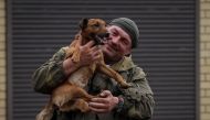 A Ukrainian serviceman pets a dog in the town of Zolochiv, Kharkiv region, Ukraine, on September 12, 2022. (REUTERS/Gleb Garanich)