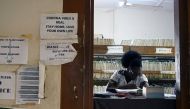 A health worker sits behind a table in the lobby of a clinic in Adukrom, Ghana April 27, 2022. Picture taken April 27, 2022. REUTERS/Cooper Inveen


