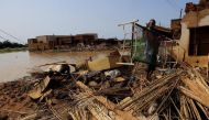 A man collects his belongings after sustaining water damage to his house during floods in Al-Managil locality, in Jazeera State, Sudan, on August 23, 2022. REUTERS/Mohamed Nureldin Abdallah