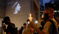 People hold candles during the funeral of Britain's Queen Elizabeth, outside the British Consulate-General, in Hong Kong, China, on September 19, 2022. (REUTERS/Tyrone Siu)