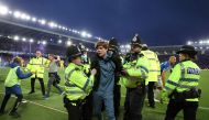 Police officer detain Everton fans as they celebrate avoiding relegation from the Premier League during a pitch invasion after the match against Crystal Palace at the Goodison Park in Liverpool on May 19, 2022.  File Photo / Reuters
