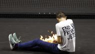 A protester lights a fire on the court during the Laver Cup match between Team Europe's Stefanos Tsitsipas and Team World's Diego Schwartzman at 02 Arena, London, Britain, on September 23, 2022. (Reuters/Andrew Boyers)
