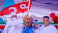 APC party's new presidential candidate Bola Tinubu raises a party's flag with Nigeria's President Muhammadu Buhari next to Abdullahi Adamu, the APC party chairman, during the party convention in Abuja, Nigeria, on June 7, 2022. (Nigeria's Presidency/Handout via REUTERS)